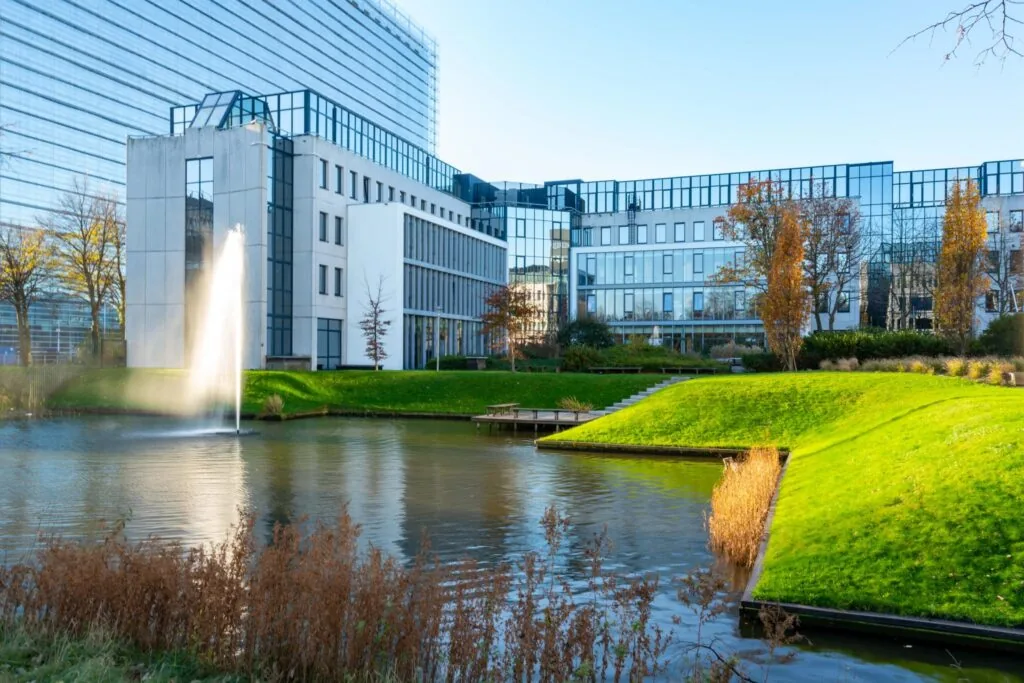 Moderne kantoorgebouwen aan de De Bruyn Kopsstraat met een vijver, fontein en groen aangelegde oever.